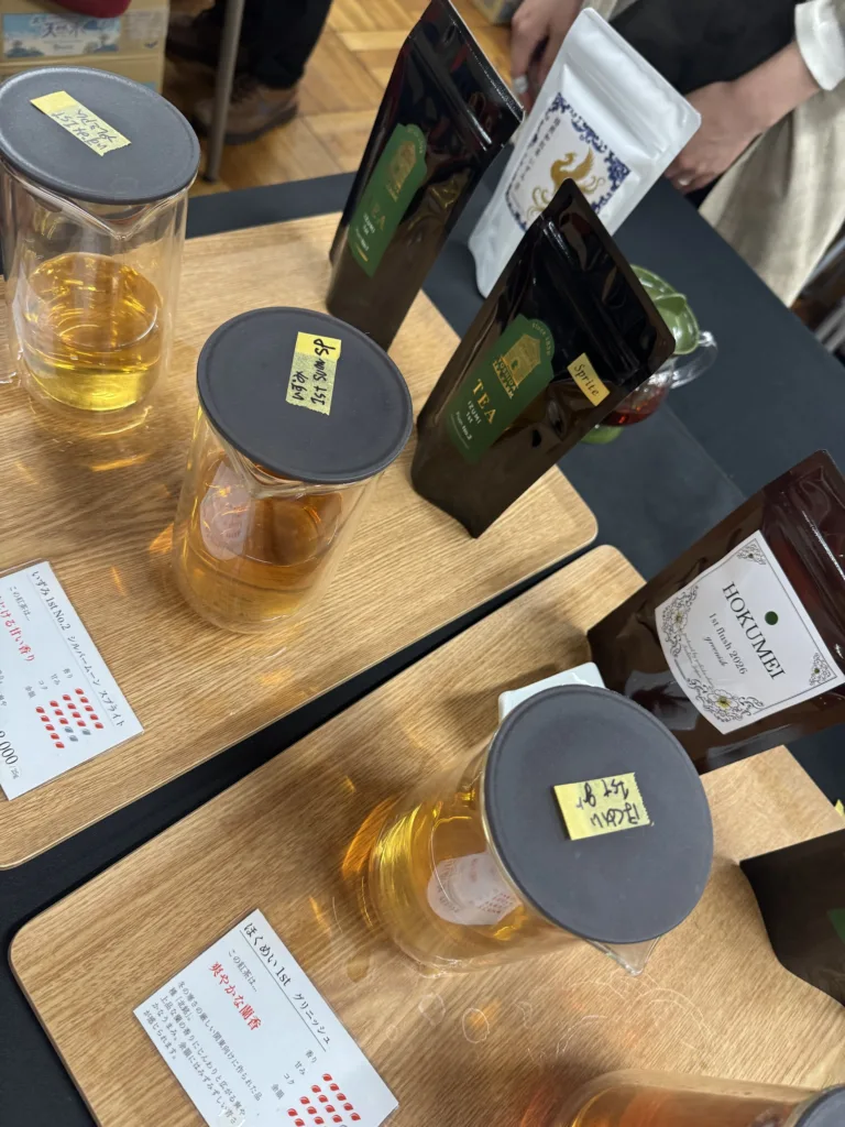 吉田茶園の試飲の卓に並ぶ、いずみ 1st とほくめい 1st の札と袋